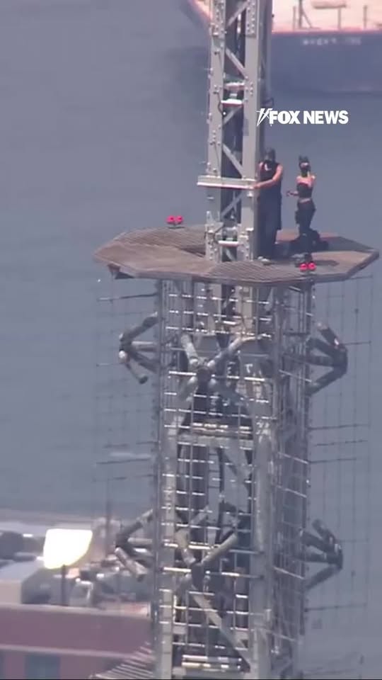 BREAKING: Man appears to propose to woman at the top of the Empire State Building.

The pair were earlier seen climbing the spire and holding a banner reading, "When the power of love beats the love of power, the world knows peace."