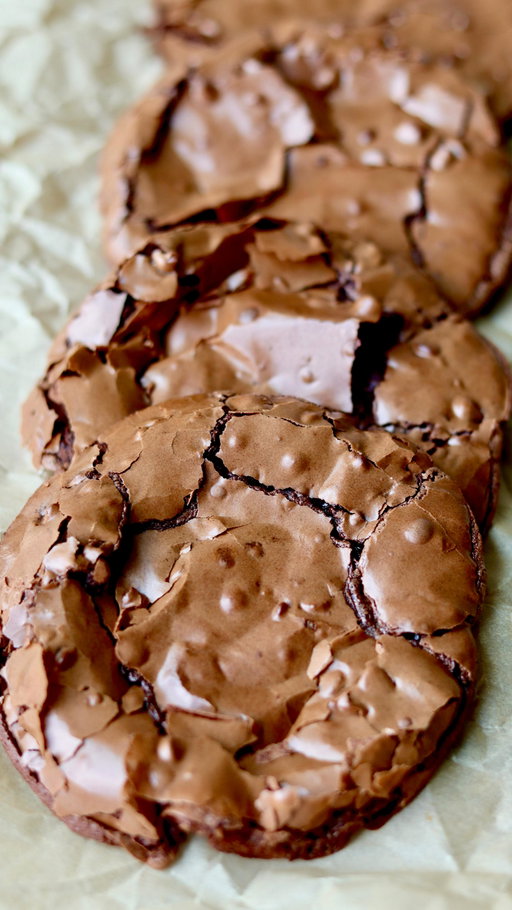 all the best parts of a brownie in cookie form 🍫

crinkly top + chewy + fudgy = the most delicious cross between a brownie and a cookie! 

**if your cookie dough is super runny, add more powdered sugar or refrigerate for 30 mins!** 

ingredients:
350g powdered sugar (a little less than 3 cups, but you can use 3 cups as well since this recipe is pretty forgiving)
65g cocoa powder (8 - 10 tbsp) – you can also adjust this to 60g of cocoa powder if you prefer a sweeter cookie!
1/2 tsp salt
3 egg whites from 3 large eggs! (about 1/2 cup of liquid egg whites)
1/2 to 1 cup semi sweet chocolate chips (optional but recommended!) – depending how much chocolate you like! you can also use milk but i'm a semi sweet/dark choco girl.
1 tsp instant coffee (use 1/2 tsp if you are caffeine sensitive)
1 tsp vanilla bean paste (optional but adds great flavor)

directions:
preheat oven to 350°f (175°c). line a baking sheet with parchment paper and lightly butter it so the cookies do not stick.
in a large bowl, add powdered sugar, cocoa powder, salt, egg whites, instant coffee, and vanilla bean paste. stir until a thick glossy batter forms.
fold in the chocolate chips if you are using them.
scoop 2 to 3 tablespoons of batter per cookie onto the prepared baking sheet. leave at least 4 to 5 inches between each cookie because they spread a lot while baking. four to a cookie sheet will definitely prevent them from touching, but you can fit six if you do not mind if they bake into each other a bit.
place the cookie tray directly in the middle of your oven.
bake for 8 to 10 minutes or until crinkly. at 8 minutes the cookies will cool into a very fudgy texture. the longer you bake them, the less fudgy they will be. ten minutes should be the maximum baking time.
immediately after baking, use a round bowl to gently scoot and round out the cookies. this will help “fluff” up the edges, which can be a bit flat right out of the oven.
remove the cookies from the baking sheet right after shaping so they do not continue cooking on the hot tray. transfer to a cooling rack and let them cool completely before eating.
enjoy!!!

tips: 
(in the comments)
#brownie #cookies #flourless #baking #glutenfree
