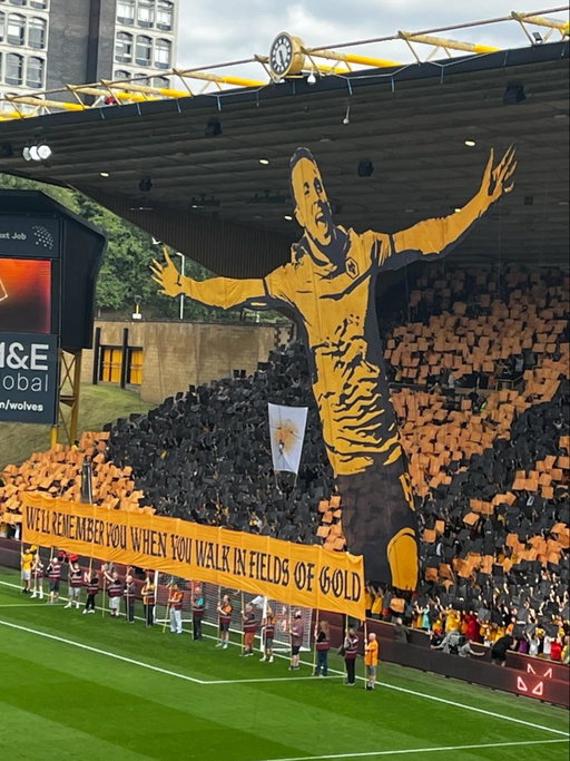 Emotional and touching moment, as Wolves pay a beautiful tribute to Diogo Jota with incredible tifo 🐺

“𝐖𝐞’𝐥𝐥 𝐫𝐞𝐦𝐞𝐦𝐛𝐞𝐫 𝐲𝐨𝐮 𝐰𝐡𝐞𝐧 𝐲𝐨𝐮 𝐰𝐚𝐥𝐤 𝐢𝐧 𝐟𝐢𝐞𝐥𝐝𝐬 𝐨𝐟 𝐠𝐨𝐥𝐝”, is the message, as a video is being played of Jota’s best moments in the Wolves shirt and the whole stadium chanting his name 🥺🕊️

Diogo Jota played at Wolves from 2017-2020 and played a crucial role in their promotion to the PL in 2017. 

Class.