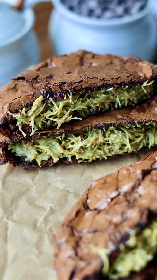 dubai chocolate brownie cookie sandwiches 🍪

ingredients: 350g powdered sugar 60–65g cocoa powder 1/2 tsp salt 3 egg whites from 3 large eggs! (about 1/2 cup of liquid egg whites) 1/2 to 1 cup semi-sweet chocolate chips (optional but recommended!) – depending how much chocolate you like. you can also use milk, but i’m a semi-sweet/dark choco girl. 1 tsp instant coffee 1 tsp vanilla bean paste 2 tbsp pistachio crème (optional for the cookie) 

filling: 4 oz crispy kataifi (brown uncooked kataifi in butter until golden) 2-3 oz pistachio crème (you can totally eyeball this) 30g tahini (again, you can eyeball this)

directions: in a big bowl, mix together powdered sugar, cocoa powder, salt, egg whites, instant coffee, and vanilla bean paste until you’ve got a thick, glossy batter. fold in chocolate chips if you’re using them. swirl in the pistachio crème (optional- the pistachio crème gets lost when baked into the cookie but the flavor is there!)  refrigerate the batter for 30–60 minutes. preheat your oven to 350°f (175°c). line a baking sheet with parchment paper and butter it so the cookies don’t stick. scoop 2–3 tablespoons of batter per cookie onto the tray. leave at least 4–5 inches between each cookie because they spread a lot. four per sheet is the safest bet!  bake in the middle of the oven for 8–10 minutes, until crinkly. if you pull them at 8 minutes, they’ll set into a super fudgy texture. if you bake longer, they’ll be less fudgy so 10 minutes max but this also depends on your oven. you can tell the cookies are done when the edges are set and the tops are crinkly.  right after baking, use a round bowl to scoot the edges in so the cookies look nice and round (and fluff up the edges a bit). transfer off the tray right away so they don’t keep cooking on the hot pan. let them cool completely. for the filling, mix the crispy kataifi with pistachio crème and tahini until it comes together. spread between two cooled cookies and sandwich it up. enjoy!!!

#dubaichocolate #brownies #cookies #baking #chocolatecookies