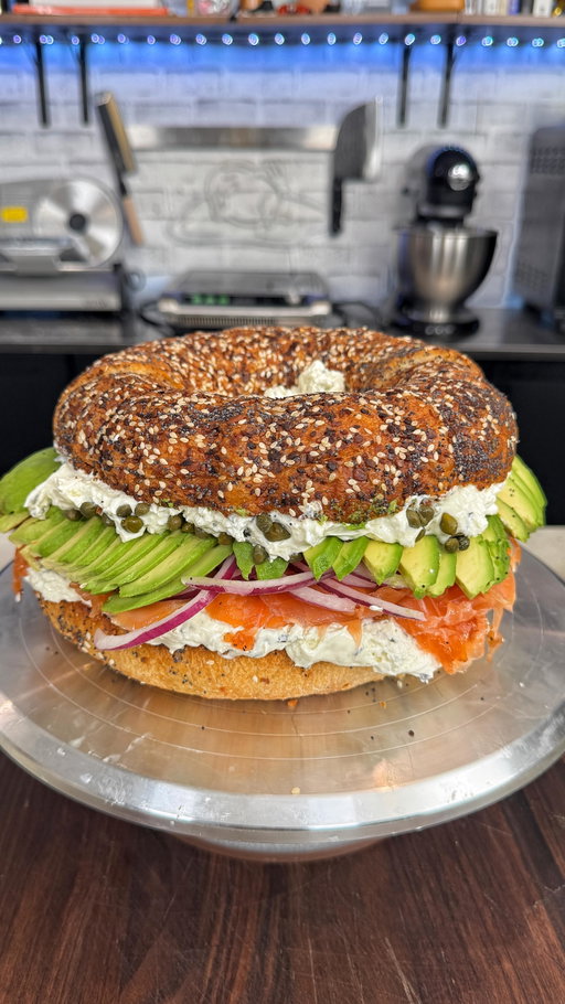 Giant Bagel Lox and Cream Cheese Cake. Check out the recipe below👇🏻

INGREDIENTS
2 pillsbury French bread containers
1/4 cup of each of the following: dried onion flakes, dried garlic flakes, sesame seeds, poppy seeds
3 lbs salmon (skin on)
2 cups sugar
2 cups salt
2 cups black pepper
6-8 large sprigs of dill
1 large red onion thinly sliced
1/2 up capers
2 large avocados thinly sliced

Lay down half the dill in a large container big enough to fit the salmon
Cover each side of the salmon in the salt, sugar and pepper and palace it on top of the dill skin side down
Add the remaining dill on top
Cover with plastic wrap and then use something heavy to weigh it down.
Place in the fridge for 48 hours
When it’s done, take it out of the tray and rinse off as much of the curing mixture as possible. Let it sit in the fridge overnight 
Slice the salmon as thinly as possible
On a sheet tray, combine the garlic, onion, poppy seeds and sesame seeds
Unwrap the french bread, and coat it in the everything bagel mixture 
Place in a greased bundt cake tray and bake at 350 for 30 minutes
Slice the large gabel in half and toast it on both sides
Layer the sandwich as follows. Cream cheese, salmon, onion, avocado
OPn the other side of the bagel, add the remaining cream cheese, and capers