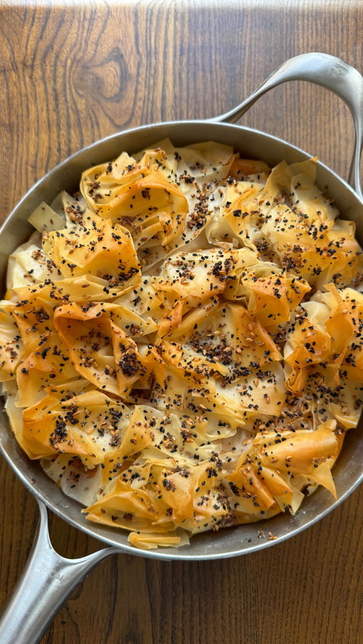First pie of the season and she’s a total baddieeee 🥧 a rich spiced lamb, ’nduja and feta ragu wrapped in golden, crunchy filo and drizzled with some hot honey for a sweet finish. absolutely gorgeous stuff. consider autumn officially launched 🍷

For 4:
2 tbsp olive oil
1 onion, finely chopped
3 garlic cloves, crushed
500g lamb mince
75g ’nduja 
1 roasted red peppers, skins removed and roughly chopped 
1 tsp cinnamon
1 tsp paprika 
2 tbsp tomato paste
200ml chicken or lamb stock
200g feta, cubed
1 pack filo pastry
80g butter, melted 
Nigella or sesame seeds, for topping
Hot honey for drizzling

1. Heat olive oil in a large pan, gently cook the onion and garlic for 5 mins then crank up the heat and brown the lamb, breaking it up.
2. Stir through ’nduja, pepper, spices and tomato paste and cook for 2 mins before adding the stock and simmering for 10 mins until thick. Cool for 20 mins then stir in the feta
3. Heat oven to 180°C fan. Brush the base of a 20cm ovenproof pan with melted butter. Lay one sheet of filo in the dish, letting edges overhang. Brush lightly with butter. 4. Repeat, layering 4 sheets, crisscrossing so the base is covered.
4. Spoon in lamb mixture, fold overhang on top. Add the remaining scrunched filo sheets on top, brushing with butter. Scatter nigella and sesame seeds.
5. Bake 35 mins until golden and crisp then drizzle with hot honey before serving.