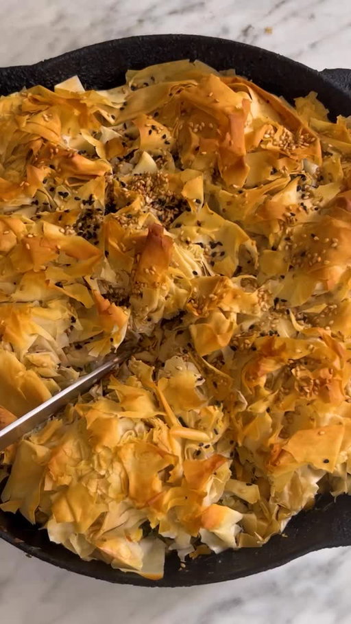 Here’s how to make @hettymckinnon’s Chickpea, Spinach and Feta Pie:

• 2 large leeks (about 1 pound), roots and wilted tops trimmed, stalks halved lengthwise and thinly sliced
• 9 tablespoons extra-virgin olive oil, divided
• Salt and pepper
• 3 garlic cloves, finely chopped
• 5 ounces baby spinach
• 1 (15-ounce) can chickpeas, drained
• 7 ounces crumbled feta
• 1 lemon, zested and juiced (3 to 4 tablespoons), plus 1 more lemon for serving
• 1 cup chopped dill
• 8 to 10 phyllo pastry sheets (about 10 ounces), thawed
• Toasted white sesame or nigella seeds (optional), for topping

Heat the oven to 375 degrees.

Prepare the leeks: Place the sliced leeks into a colander and rinse them well, rubbing to loosen any dirt. Rinse again and drain well. (There is no need to dry them, as the residual water is useful in cooking the leeks.)

Heat a 10-inch ovenproof skillet on medium-high for 1 to 2 minutes. Add 2 tablespoons of olive oil along with the leeks (the skillet will look overfilled, but it cooks down a lot). Season generously with salt and pepper and cook, stirring occasionally, until the leeks are wilted, 3 to 5 minutes.

Add the garlic and the spinach, a few handfuls at a time, adding in more as it wilts, and toss until the leaves have all softened. Turn off the heat and add the chickpeas, feta, lemon zest, lemon juice and dill. Taste and season generously with salt and pepper.

Place the phyllo sheets into a large bowl and drizzle with 5 tablespoons of olive oil. Scrunch and massage the oil into the sheets; the sheets will crumble, break up and clump up and that is fine. Scrunch the pastry, and transfer in clumps, arranging them on top of the leeks and spinach, until completely covered. Drizzle the top with the remaining 2 tablespoons of olive oil and scatter over the sesame or nigella seeds, if using.

Bake until the top is golden and crispy, 30 to 35 minutes, or until the top is golden and crispy. Allow to cool for 5 to 10 minutes. Serve with lemon on the side.