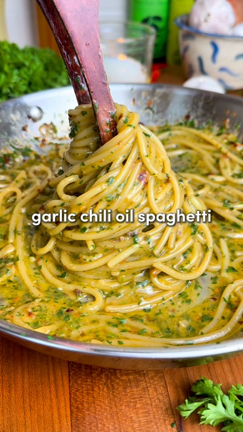Garlic Chili Oil Spaghetti 🧄 (aka Aglio e Olio)

Comment “Recipe” and I’ll send you the full recipe card for free!!

Minimal effort, max flavor. Garlicky, lightly spicy, and impossibly comforting 🫠

Ingredients:
-8 oz (225 g) spaghetti
-1/3 cup extra virgin olive oil (plus 1 to 2 tbsp more if needed)
-8 garlic cloves, thinly sliced
-1 tsp red chili flakes (or 1 tsp finely chopped fresh chili without seeds)
-1 to 1 1/2 cups reserved pasta water
-1 whole parsley stem (for infusing)
-1/3 cup fresh parsley leaves, finely chopped
-Fresh lemon zest, for garnish (optional)
-Freshly grated Parmesan cheese, for serving (optional)

Instructions:
1. Bring a large pot of aggressively salted water to a boil. Cook spaghetti until al dente. Reserve 1 1/2 cups of the starchy pasta water, then drain.
2. While the pasta cooks, heat the olive oil gently in a large skillet over medium-low. Add the garlic slices and whole parsley stem, stir constantly until the garlic turns light golden… not brown (about 3 minutes)
3. Stir in the chili flakes and a pinch of salt. Let them bloom for 30 seconds, then remove the parsley stem and take the pan off the heat.
4. Add about ½ cup of the reserved pasta water to the skillet and stir/whisk vigorously to combine with the oil. It’ll start looking creamy and slightly thick… that’s your emulsion forming.
5. Return the pan to medium-low heat and add the drained spaghetti along with another splash of pasta water. Here’s the key: Toss everything aggressively with tongs for 1–2 minutes, drizzling in 1 to 2 more tablespoons of olive oil and a bit more pasta water as you go. Alternate between the two while tossing nonstop. The sauce should turn silky and glossy. If it looks dry or clumpy, add more water; if it looks thin, keep tossing.
6. Turn off the heat and stir in the chopped parsley. Taste and add a tiny pinch of salt if needed.
7. Plate immediately, spooning any extra sauce from the pan over the top. Garnish with lemon zest and a sprinkle of Parmesan if you’d like (add cheese after plating so it doesn’t break the emulsion… not traditional, but worth it 👀).