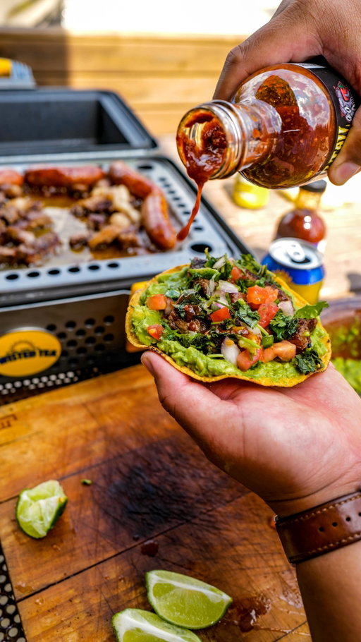 Twisted Tea tostada slinger @victorlopez_mijo loads up a crunchy bite with crispy ribeye chicharrones, avocado, pico and @evil_cooks twisted tail taco sauce.

#tostada #grilling #tailgating #charcoal #bbq #barbecue #outdoorcooking #pitmaster #livefire #chicharrones #avocado @twistedtea