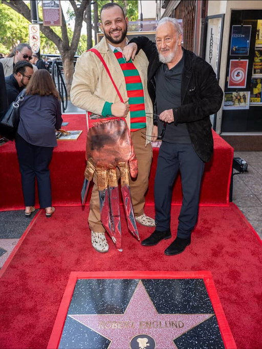 Congratulations to legend, friend, and incredible human @officialrobertenglund on receiving his star on the Hollywood Walk of Fame! What an honor to celebrate such an iconic performer whose work has haunted and inspired generations.
I was lucky enough to work with Robert when he directed me in Killer Pad, and I’ll never forget how much pride he took in his legacy from his performances to his incredible collection of memorabilia from around the world. He’s the one who taught me to collect foreign posters of my own films, and I’ve loved doing it ever since. Today’s ceremony was pure Hollywood magic. Fans lined the street outside the historic Larry Edmunds Bookshop (the same spot where Robert’s old roommates once worked) creating a full circle moment worthy of the silver screen he has loved so much. It reminded me why I love this town so deeply: when the fans, the artists, and the history of cinema all come together to celebrate a life dedicated to storytelling. If you get the chance, go watch the speeches from Eli Roth and Heather Langenkamp they were masterful. Eli’s was electric, and Heather’s words as both a fan and a friend genuinely moved me.
As an actor, a fan, and a lifelong lover of Hollywood, it was unforgettable to witness someone I’ve worked with be honored in such a legendary way.
For the occasion, I constructed this Freddy glove bag (with the help of my fella Ty bb! ) as a tribute. Robert graciously signed it and so did I. Like a journal entry. One day, I’ll auction it off for charity… (after I enjoy it in my home for a bit).

Here’s to celebrating the icons who came before us and to the dream of one day joining them on that famous boulevard. Happy Halloween, and congratulations again to a true master of horror and a genuinely kind soul beneath the glove. @hwdwalkoffame 
@hollywoodchamberofcommerce 
📸: @imagerybyoscar
👞: down to the shoes 😉