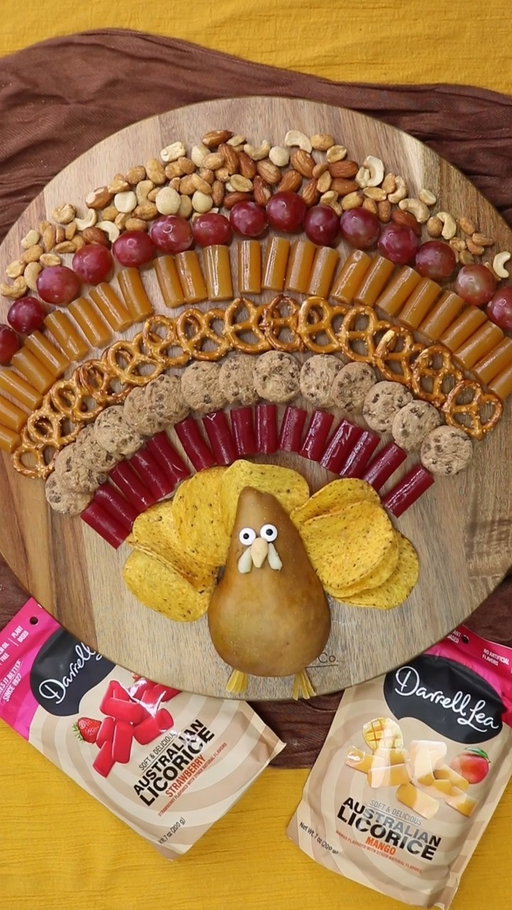 Gobble up this irresistible Turkey snack board for Thanksgiving! 🦃🍁

What you'll need: ​
🧡 Darrell Lea Soft Australian Mango and Strawberry Licorice ​
🧡 An assortment of snacks to create the feathers - we've used crackers, nuts, pretzels and grapes ​
🧡 Half a brown bosc pear ​
🧡 Edible glue ​
🧡 Candy eyes ​

Method: ​
1️⃣ Fan out all of the snacks to look like turkey feathers on a circular platter. 
2️⃣ Cut the brown bosc pear lengthways in half and place the cut side down at the bottom of the board. Use edible glue to attach the candy eyes and cashew beak. ​
3️⃣ Cut the shape of the legs from a piece of licorice and place at the bottom of the pear. You now have an adorable and delicious Turkey Snack Board that’s sure to impress and satisfy all your guests! ​

#DLMakesItBetter #PalmOilFree #Thanksgiving #Turkcuterie