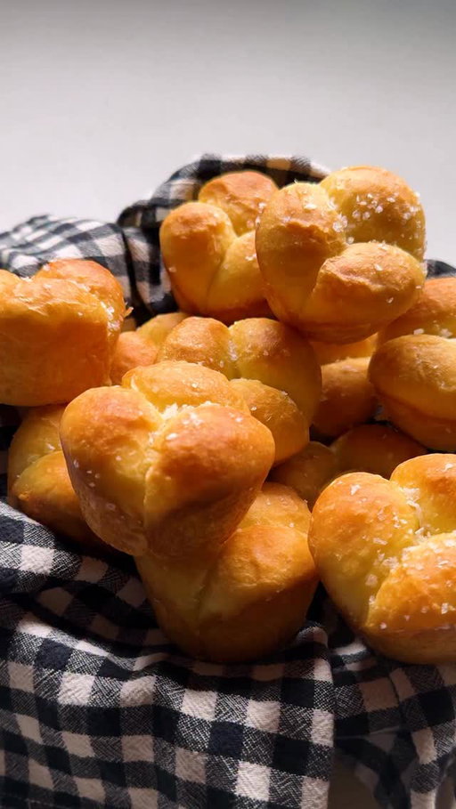Here’s how to make @samanthaseneviratne’s Cloverleaf Rolls:

• 1 (¼-ounce/2¼ teaspoons/7 grams) package active dry yeast
• 2 tablespoons granulated sugar
• ½ cup/120 milliliters whole milk, warmed to 105 to 110 degrees
• 6 tablespoons/85 grams unsalted butter, plus more for the pan
• 2 cups/255 grams all-purpose flour
• 1 teaspoon kosher salt, plus more for sprinkling
• 1 large egg

Stir the yeast and 1 teaspoon of the sugar into the milk. Set aside until foamy, about 5 minutes. Melt 4 tablespoons of the butter.

Meanwhile, in the bowl of a stand mixer with the dough hook attached, combine the remaining sugar, flour and salt. With the mixer on low, add the yeast mixture and the egg and knead until the dry ingredients have been incorporated (you may have to help it along at first with a spatula) and the dough is smooth, about 5 to 10 minutes. Carefully add the melted butter (the dough will slosh around in the butter for a few minutes, but will eventually absorb it all) and continue to knead the dough until smooth, increasing the speed to medium, another 5 to 10 minutes. The dough will be shiny and elastic; if it’s at all sticky, scrape down the sides of the bowl and gather the dough into a neat ball (no need to add extra flour). Cover the bowl with plastic and set aside to rise in a warm place until doubled, about 1 to 2 hours.

Butter a standard 12-cup muffin tin. Gently tip the dough out onto a work surface. You shouldn’t need flour at this point. Divide the dough into 12 equal pieces. Work with one piece at a time and keep the other pieces covered. Divide each piece into 3 equal pieces, roll each piece into a tight ball and place into one cup. Repeat with the remaining dough. Cover the tray lightly with plastic wrap and set aside to double again, about 45 minutes to 1 hour. The dough should look puffy and spring back slowly when pressed gently.

Heat the oven to 375 degrees. Melt the remaining 2 tablespoons butter. Remove the plastic wrap and without deflating the dough, gently brush the rolls with butter. Bake until puffed and golden, about 10 to 12 minutes. Remove from the oven and brush with more butter and sprinkle with salt. Serve warm.