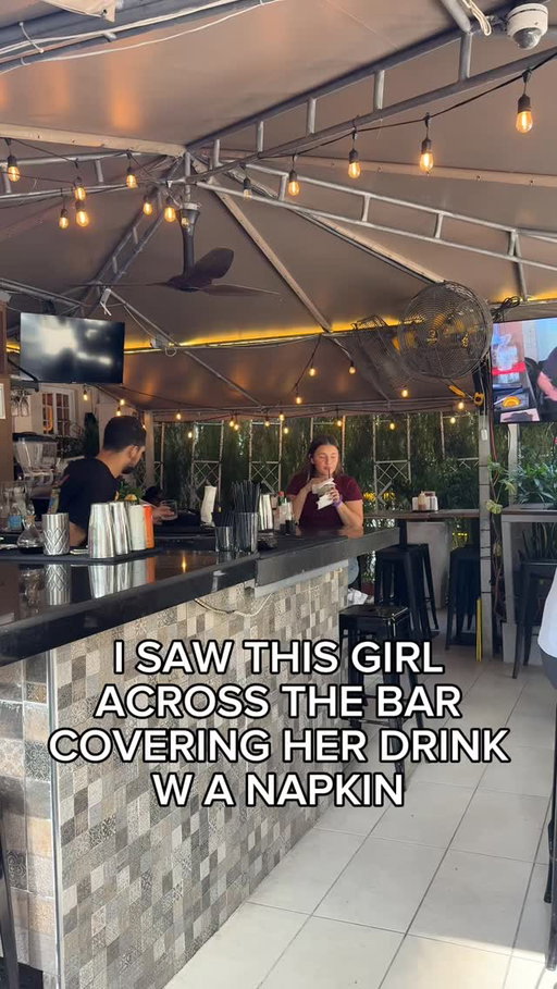 I saw this girl across the bar covering her drink with a napkin.