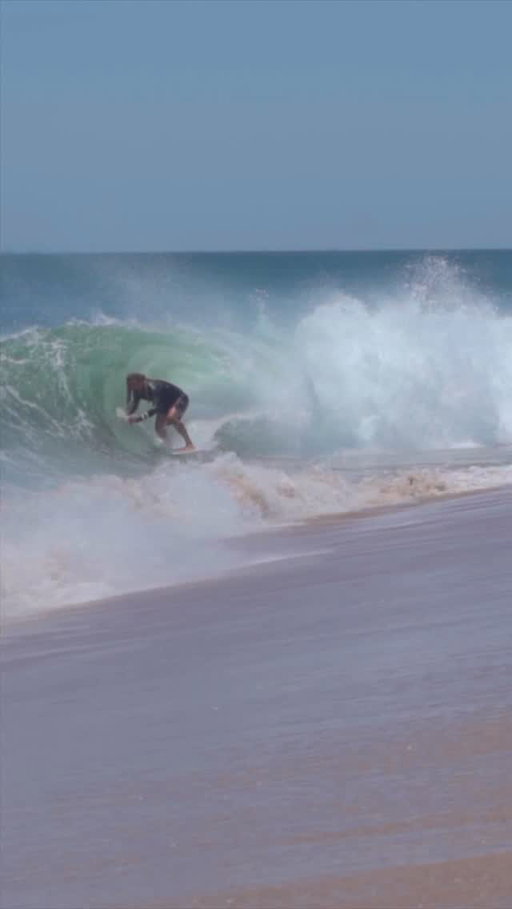 Backside wrap skimboarding in some hard offshore winds!