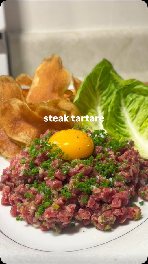 MY TOP 3 REELS OF THE YEAR - #2: How to Make Steak Tartare 🥩🥩

One of my favourite parts of creating content is exposing people to foods they wouldn’t normally eat, and it turns out A LOT of people haven’t tried beef tartare! There was a huge debate in the comments of the original video regarding whether or not beef tartare is delicious (spoiler… IT IS), and I’d love to keep promoting that narrative 🙌. This reel is without a doubt one of my favourites of 2025, and it helped define what kind of content I want to make going forward. 

RECIPE BELOW ⬇️ 

INGREDIENTS:
- 200g cut of lean beef from a reputable butcher. Beef tenderloin for a more tender texture, eye of round or top round for a bit more chew.
- 1 shallot
- 4 gherkin pickles
- 2 tsp capers
- 2 brown anchovies
- 1/4 bunch parsley
- 1/4 bunch chives
- 1 tbsp Dijon mustard
- 1/2 lemon
- olive oil, tobasco, Worcestershire to taste
- salt and fresh cracked pepper to taste
- 1 large russet potato 
- 1L canola oil (for frying)
- 1 head gem lettuce
- 1 egg yolk

INSTRUCTIONS:

TARTARE: 🥩
1) Thinly slice your beef approx. 1/2 cm thick, and lay on a sheet pan lined with parchment. Place in the freezer until beef is semi-frozen.
2) While waiting for your beef, finely chop your shallot, gherkins, capers, anchovies and parsley, add to a chilled mixing bowl. Finely chop chives and set aside.
3) When beef is semi-frozen, dice it into approx 1/2 cm dice, and mix with your other chopped ingredients.
4) Mix with Dijon and lemon juice, a generous drizzle of olive oil, as well as a few dashes of tobasco and Worcestershire. Season with salt and freshly cracked pepper. Taste your tartare and adjust seasoning. 
5) Plate your tartare on a chilled plate, garnish with chives and your egg yolk. Serve with potato chips and lettuce leaves.

#steak #recipe #homecooking