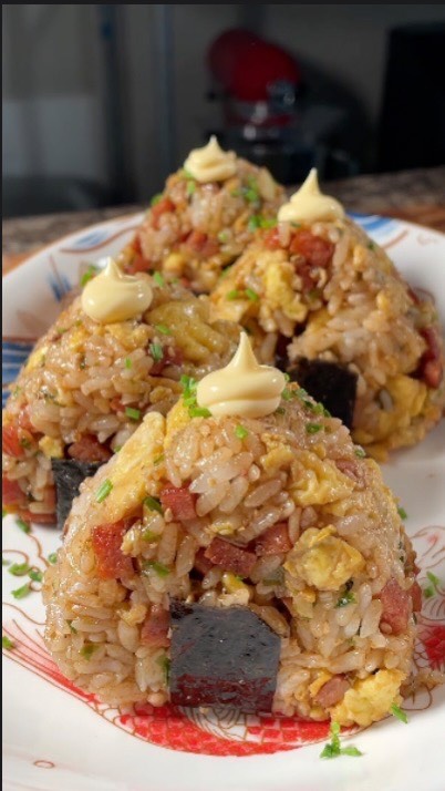 Finally at #12 is BBQ Spam Onigiri by @groovyfoodiess with 10.3M views!!🍚🥩
Ingredients:
-1 cup rice, cooked
-½ can Spam, cubed
-1 Tbsp soy sauce
-1 Tbsp sugar
-2 Tbsp bbq sauce
-3 eggs
-spray oil
-4 Tbsp furikake

Garnish:
-chives
-kewpie mayo
-seaweed strips

Steps:

1. Cook rice according to package instructions and set aside to cool.
2. Cube spam into small bites, set aside.
3. In a large pan on medium heat, spray with cooking oil before adding spam. Toast on all sides until slightly brown, about 3 minutes.
4. Add in the soy sauce, sugar, and bbq sauce, and cook for another 3 minutes or until the sauce thickens to liking. Remove and set aside.
5. In a bowl, mix your eggs to scramble.
6. In the same pan over medium heat, spray with cooking oil and scramble the eggs until set, about 1 minute. Set aside.
7. In a large mixing bowl, combine cooled cooked rice with spam, scrambled egg, and furikake.
8. Mix well and form into round balls.
9. Wrap the rice balls with the seaweed strips and top with kewpie and chives.
10. Enjoy immediately!