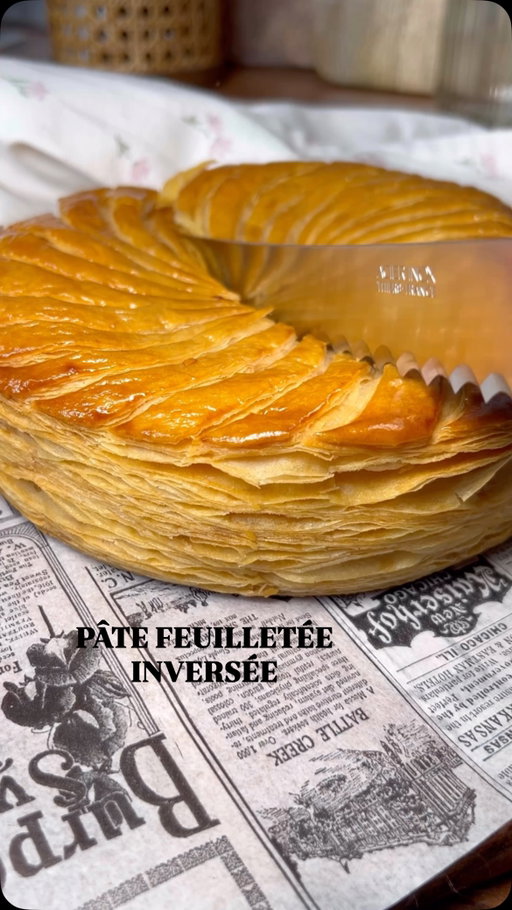 Pâte feuilletée inversée ⬇️

Pour 1 galette de 20 cm

Le beurre manié :
225g de beurre AOP Charentes Poitou
100g de farine 

La détrempe :
187g de farine T65
85g d’eau froide 
60g de beurre mou 
8g de sel 
2g de vinaigre blanc

Tu prépares le beurre manié, tu l’étales sur une plaque en silicone au dimensions 30x15 environ. Tu réserves au frigo le temps de préparer la détrempes. 
Pour la détrempe, tu mélanges tous les ingrédients jusqu’à ce que tous les ingrédients bien incorporés, ne surtout pas trop la pétrir, sinon la pâte feuilletée va se rétracter à la cuisson. 
Généralement je fais cette étape la veille au soir et je laisse reposer toute la nuit (question d’organisation) mais 2h suffisent. 
Tu sors la pâte du frigo et tu la déposes sur le plan de travail fariné (le beurre face à toi) tu attends 10/15 min avant d’étaler la pâte sinon le beurre va se casser et le feuilletage sera moins joli. 
Tu abaisses la pâte sur environ 5mm d’épaisseur et tu effectues un 1er tour double. Tu réserves au frigo minimum 1h et tu fais 2 autres tours double avec minimum 1h entre chaque tour et à la fin du 3ème tour double (2h c’est mieux;)) 
Tu abaisses la pâte sur environ 3/4 mm d’épaisseur ( n’hésite pas à soulever la pâte du plan de travail et faire des «vagues» pour éviter qu’elle se rétracte une fois les cercles découpées). 
Tu fais tes découpes pour la recette choisie. 
À savoir: 
- Il ne faut pas raccourcir les temps de repos si tu veux un beau feuilletage. Perso je la fais parfois sur 3 jours et le résultat est top. 
- Il faut toujours travailler la pâte feuilletée froide (pas à la sortie du frigo car le beurre va se casser mais 10/15 min après c’est parfait. 
- Pour la galette des rois, mets la galette au congélateur 15 min avant de faire la dernière découpe du cercle au cutter (ou bistouris) pour avoir un feuilletage qui lève bien. 
- Cuisson : 50 min à 1h à 170 degrés 

#patefeuilletee#recipe#galettedesrois#epiphanie#pastry