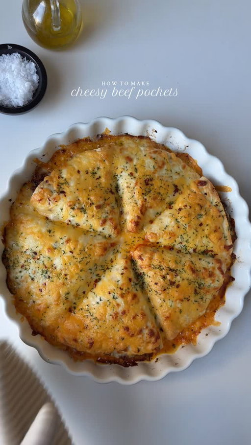 Cheesy beef pockets 🧀 

Ingredients 

1 lb of ground beef, 80% lean and 20% fat.
1 onion, finely diced
1 tbsp fresh garlic, minced
1 cup bell pepper, chopped 
1-2 Serrano pepper, chopped ( optional )
3 tbsp tomato paste
Salt to taste
1 tsp garlic powder 
1 tsp smoked paprika powder 
1/2 tsp chili powder 
1 tsp red chili flakes 
1 tsp black pepper 
1 tsp cumin powder 
3/4 cup water
2 tbsp oil

To assemble: 
4 large tortillas, cut into half
3 tbsp Butter/garlic butter 
1 cup mozzarella cheese 
1 cup cheddar cheese 

Method:

In a pan, heat oil on medium heat. Once the oil is hot, add onions and garlic. Sauté them for 1 to 2 minutes until the onions become translucent. Then, add the minced beef and cook it for 3 to 4 minutes until it changes color. Season the mixture with salt, pepper, paprika powder, garlic powder, red chili powder, cumin powder, and red chili flakes. Mix well to combine all the ingredients. Add tomato paste and sauté for 2-3 min. Finally, add water to the pan and cook on medium heat for 8 to 10 minutes, or until the beef is cooked through and the water is almost evaporated.

Add the bell peppers and Serrano peppers to the pan and sauté them for 2 to 3 minutes. Then, turn off the heat and set aside.
Preheat oven to 400°F.
Take the tortilla wraps and cut them in half. Place shredded mozzarella cheese in the center of each half, followed by 2–3 tablespoons of the cooked beef filling. Fold and seal the tortilla to form a triangle, then set it aside. Repeat with the remaining tortillas until all are filled with cheese and beef.

Grease a circular baking dish with garlic butter. Arrange the prepared wraps in the dish. Brush the tops with more butter, then sprinkle with mozzarella and cheddar cheese. Bake for 15–20 minutes, or until the cheese is fully melted and bubbly.
#recipe #baking