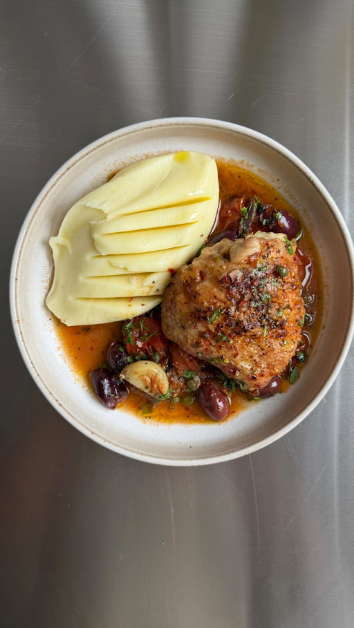 The easy but most flavour packed meal I’ve made in a long while. My puttanesca chicken traybake with creamy AF mash. The perfect bung-it-all-in midweek meal, also perfect for hosting! Salty, punchy, jammy and wildly comforting and heck, that mash might just be the best bit! 🍗

For 4
4 large bone-in, skin-on chicken thighs
600g cherry tomatoes
160g Kalamata olives, pitted
2 tbsp capers
1 x tin anchovies in oil (don’t drain)
1 lemon peel
8 garlic cloves, peeled & left whole
1 tbsp dried oregano
1 tbsp chilli flakes
2 tbsp olive oil
1kg floury potatoes, peeled and chopped
150g butter
Handful parsley, finely chopped

1. Heat oven to 190°C fan. Tip the tomatoes, olives, capers, lemon peel, anchovies (with oil), garlic, oregano, chilli flakes into the tray and toss.
2. Nestle chicken thighs on top, skin-side up, drizzle with olive oil and season
3. Roast for 45–50 mins until the chicken is golden and the tomatoes have burst into a rich, salty sauce.
4. Meanwhile boil the potatoes for around 25 mins in salted water, drain and steam dry. Mash with butter until super smooth and creamy & season well.
5. Spoon mash onto plates and top with chicken and all those punchy puttanesca juices.