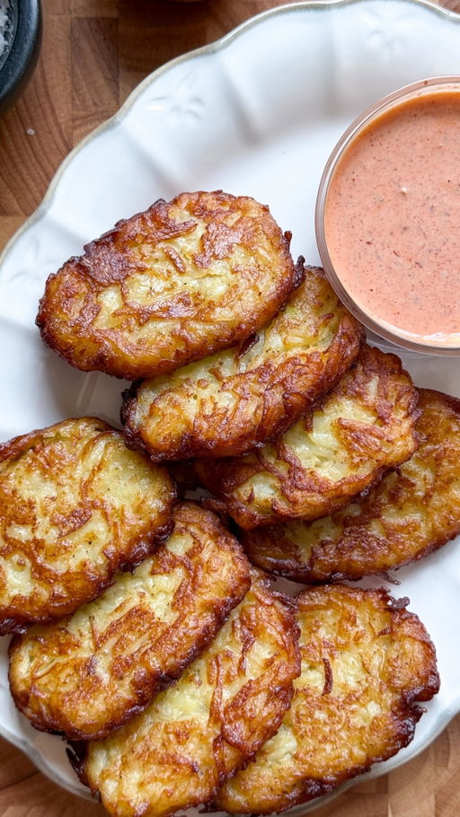 Garlic parmesan hashbrown 🥔 

Ingredients:

5 large russet potatoes
1 egg
2 tbsp cornstarch
Salt, to taste
1 tbsp garlic powder
1 tsp black pepper
1/2 cup freshly grated Parmesan cheese 
Oil, for frying

Method:

Peel and wash the potatoes, then partially boil them in salt water for 10 minutes.
Once cooled, finely grate the potatoes using a shredder.
In a bowl, combine the grated potatoes, egg, cornstarch, salt, pepper, garlic powder, and Parmesan cheese . Mix well.
Shape the mixture into oval-shaped hash browns.
Place the hash browns on a lined sheet and freeze for at least 1 hour. 
Heat oil in a pan over medium-high heat. Once hot, reduce the heat to medium-low.
Shallow-fry 3-4 hash browns at a time for 4 minutes on each side, until golden brown and crispy. Serve hot and enjoy!
#hashbrown #recipe