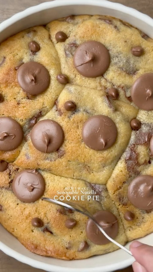 Ooey-Gooey Scoopable Nutella Cookie Pie🤤

Yields: 15-16 Chunky Cookies
INGREDIENTS:
 230g Cold Chopped Unsalted Butter 
160g Caster Sugar 
160g Light Brown Sugar 
450g Chocolate Chunks or chips 
475g Plain Flour 
1 tsp Salt
3 tsp Baking Powder 
3/4 tsp Baking Soda 
2 Eggs 
1 Egg Yolk 
1 tsp Vanilla 
INSTRUCTIONS:
•Cut cling wrap into small squares. Scoop ½ teaspoon Nutella onto individual cling-wrap squares. Fold to seal and freeze until solid. (Repeat for however many Nutella stuffed cookies you plan to make.)
•In a large mixing bowl, add the cold cubed butter and whisk until slightly creamy. Add the white sugar and light brown sugar, then whisk together until well combined and fluffy.
•Add the eggs, vanilla extract, and chocolate chips or chunks. Whisk until fully incorporated.
•Add the flour, baking powder, baking soda, and salt. Gently mix until just combined, do not overmix.
•Portion the dough into 90g balls. Press a frozen Nutella piece into the centre of each dough ball, seal well, and roll into a smooth ball.
•Place the stuffed cookie dough balls onto a tray and freeze for at least 30 minutes (or overnight for best results).
•Preheat oven to 180°C (350°F).
•Take any shape baking dish circle, square, rectangle anything and line it with parchment paper. Arrange frozen cookie dough balls in it leaving some space between them.
•Bake for 10-15 minutes (timing depends on the type of pan) or until the tops are lightly golden while the centres remain soft and gooey.
•Remove from the oven and let cool slightly.
•Serve warm with ice cream and chocolate sauce enjoy!✨
NOTE: Store any extra dough balls in an airtight container or freezer bag and freeze for later. Whenever a cookie craving hits, bake straight from frozen🫶🏻

#cookie #nutella #usareels #cookiepie foodstagram 
|worldreels, food reels, viral reels, dessert, ooey-gooey cookie pie, USA, reels, trending, viral, baking, recipes