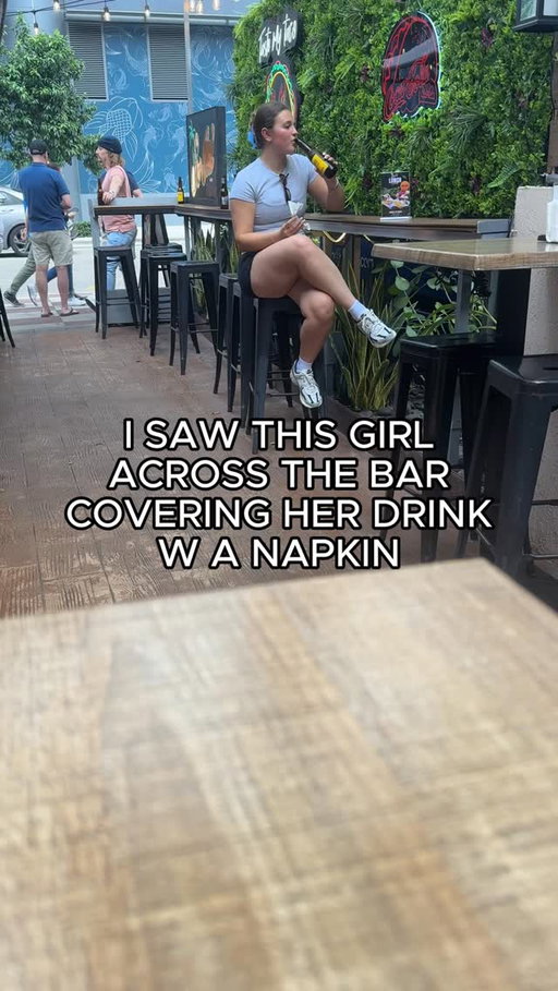 I saw this girl covering her drink with a napkin.