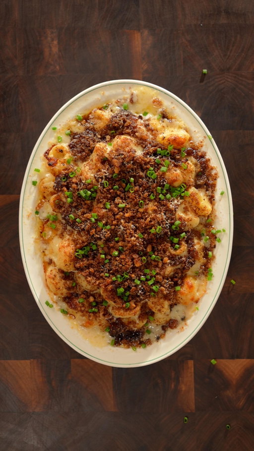 French Onion Mac and Cheeeese 🧀

Why are we like this

Ingredients

Caramelized Onions:
- 4 Yellow onions
- Salt
- 2 TBSP Butter
- 1/4 cup Beef stock
- 1 TBSP balsamic vinegar

Mac and Cheese:
- 340 g pasta (I used rigatoni)
- 3 Tbsp butter
- ¼ tsp paprika
- 1/4 tsp mustard powder
- 3 Tbsp flour
- 3 cups milk
- 1 cup mozzarella
- 1 cup cheddar
- 1 cup fontini (raclette works great also)
- 1/4 cup blue cheese (Optional)
- Pecorino (Optional)
- Chives

Bread Crumbs:
- French Bagette
- Olive Oil
- Salt

Instructions

Caramelized Onions:
- Cook chopped onions with salt in butter on a medium low heat pan for 35 minutes while stirring every 5 minutes. Deglaze with beef stock and balsamic vinegar to then finish cooking for another 15 minutes while also stirring every 5 minutes.

Bread Crumbs:
- Drizzle olive oil on slices of bread with salt to then bake in the oven at 400F until crispy and blend in a food processor.

Mac and Cheese:
- Melt butter in a low heat pan to cook chopped shallots, chopped garlic, paprika, mustard powder before whisking in flour.
- Slowly incorporate the milk 1 cup at a time while whisking until the roux is consistently smooth.
- Mix in shredded mozzarella, cheddar, fontina, and blue cheese.
- Immidietely fold in pasta that is al dente.
- Layer mac and cheese with caramelized onions, mozzarella, pecorino and bread crumbs in a baking pan to bake at 360F for 20 minutes.