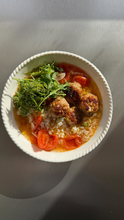 Garlic & cherry tomato brothy rice with feta meatballs. Truly my go to when I’m stuck on what to eat. Comforting, clean, herby and light but still deeply satisfying. More proof that brothy rice with never let you down! 

For 2
250g pork mince
50g feta, finely crumbled
Handful dill, stalks very finely chopped (save fronds for later)
20g panko breadcrumbs
1 shallot, finely chopped 
1 tsp dried oregano
1 tsp fennel seeds 
150g cooked sticky rice 
4 garlic cloves, thinly sliced
200g cherry tomatoes, halved
750ml good-quality bone broth
A handful of rocket

1. In a saucepan heat 1 tbsp olive, add the sliced garlic and cherry tomatoes and cook gently until fragrant, for around 4 mins 
2. Pour in the broth and simmer for 15 mins, adjust the seasoning 
3. In a bowl, mix the pork mince, feta, finely chopped dill stalks, panko, oregano, shallot, fennel seeds, some salt and lots of black pepper. Roll into small meatballs.
4. Heat olive oil in a wide pan over medium heat and brown the meatballs all over until golden. Remove and set aside.
5. Spoon your cooked rice into bowls, pour over the broth, add your meatballs on top and finish with rocket, chopped dill fronds, and an extra drizzle of olive oil