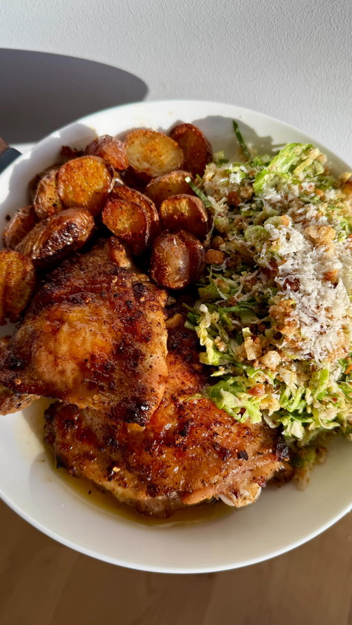 Roasted Herby Lemon Chicken Thighs and Caesar Brussels Sprouts Salad 
Recipe:
2 pounds Chicken Thighs: 
3 tablespoons olive oil 
1 teaspoon onion powder 
1 teaspoon garlic powder 
1 teaspoon red pepper flakes 
1 teaspoon dried oregano	
1 1/2 teaspoons salt 
1/2 teaspoon pepper	
1 lemon, zested 
1/2 a lemon, squeezed	
-Preheat oven to 425°F. Add olive oil, seasonings, lemon zest and juice to a bowl. Mix. Add chicken and coat all sides. Place chicken in an oven safe baking dish and cook for 30-40 minutes, until internal temperature reaches 165°F and skin is crispy.

1 pound Mini Red Potatoes:
2 tablespoons olive oil
1 teaspoon paprika
1 teaspoon onion powder
1 teaspoon garlic powder
1 teaspoon salt
1/4 teaspoon pepper
-Cut potatoes in half and add to a pot with water. Season with salt and boil until almost fork tender. Drain and place potatoes on a baking sheet. Cover potatoes with olive oil and seasonings. Bake in the preheated oven for 20-25 minutes or until they reach desired crispiness.

Caesar Brussels Sprout Salad: 
2 pounds brussels sprouts, finely chopped

Crouton Crumbs:
1/2 a baguette, cut into cubes
2 tablespoons olive oil 
1/4 teaspoon salt
1/4 teaspoon pepper
1/2 teaspoon garlic powder
1/2 teaspoon onion powder 
-Add bread to a bowl and coat with olive oil and seasonings. Pour onto a baking sheet and bake for 8-10 minutes, until crispy and golden. In a food processor, add croutons and pulse to create crouton crumbs. 

Caesar dressing:
 1 teaspoon anchovy paste 
 2 teaspoons dijon mustard
 5 garlic cloves, minced 
1/2 cup mayonnaise
1 teaspoon Worcestershire sauce
1/4 cup lemon juice
3/4 cup Parmigiano-Reggiano, grated 
1/4 teaspoon salt
1/4 teaspoon pepper
-In a bowl, add anchovy paste, mustard, and garlic. Whisk together. Add mayo, Worcestershire sauce, lemon juice, 1/2 cup Parmigiano-Reggiano, salt, and pepper. Whisk until fully combined.
-In a large bowl, add Brussels sprouts and toss in Caesar dressing, crouton crumbs, and remaining Parmigiano-Reggiano. Enjoy!
#recipe #easyrecipe #healthyrecipe #food