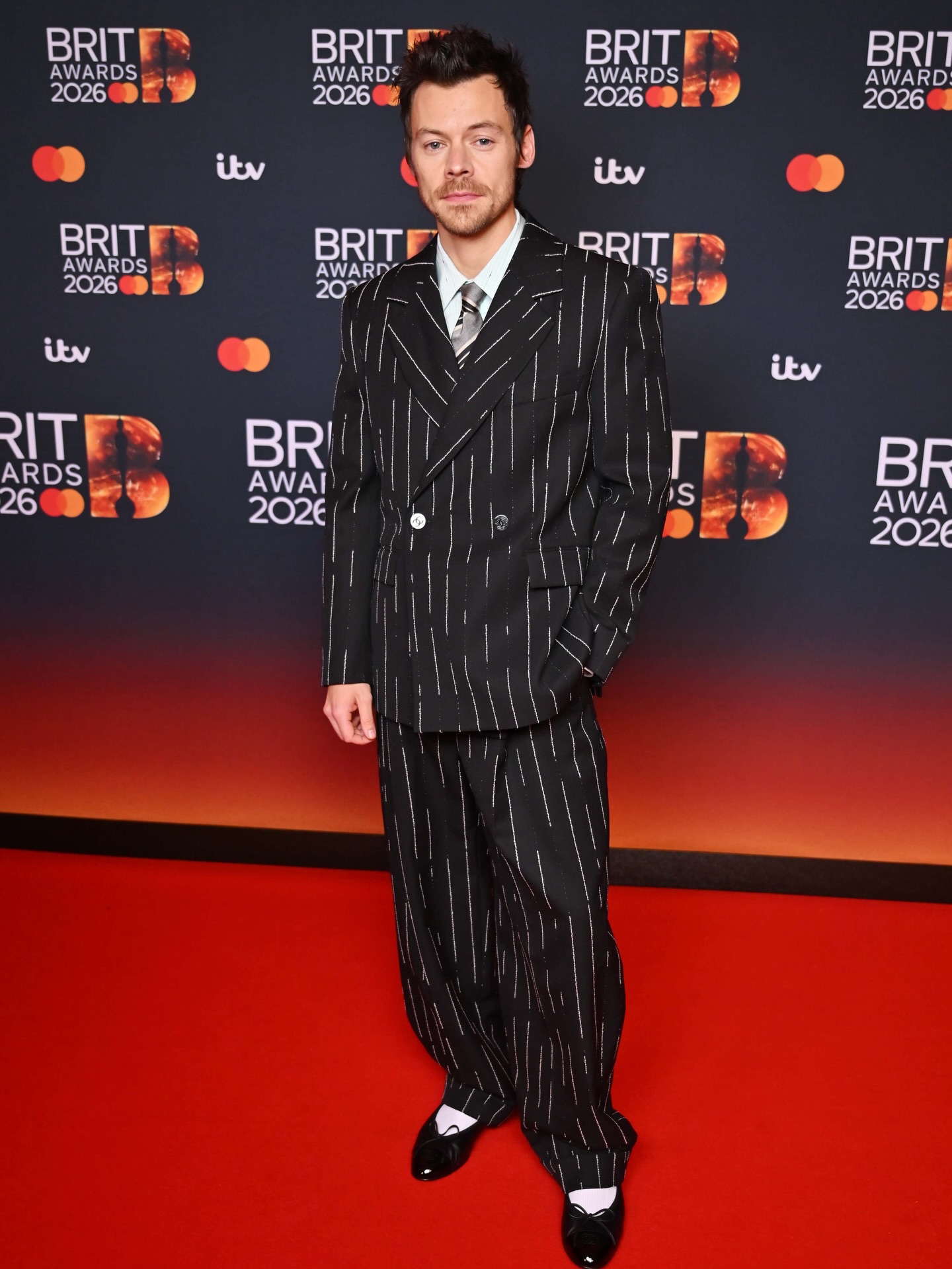Harry Styles looking sharp in pinstripes at the Brit Awards today 🔥