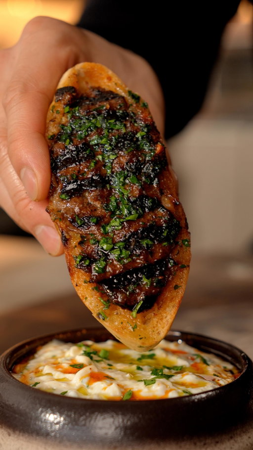 Make her some Arayes

Ingredients

Arayes:
- 500g ground beef or lamb
- 1 onion
- 2 cloves garlic
- 2 tbsp tomato paste
- 1/3 cup chopped fresh parsley
- Spices: 1 tsp cumin + 1 tsp coriander + 1 tsp paprika + 1 tsp cinnamon + 1 tsp allspice + 1 tsp Salt & black pepper
- Mozzarella (Optional. I had some leftover cheese.)
- Pita bread
- Olive oil

Garlic Sauce:
- 12 garlic cloves
- 2 shallots
- 2 tsp sesame
- Olive oil
- 1 cup greek yogourt
- 1 TBSP parsley
- 1 tsp chilli oil
- 1 tsp salt

Instructions

Arayes:
- Add ground meat with chopped parsley, tomato paste and spices in a bowl. Grate an onion and squeeze out its juices to then add it into the bowl with minced garlic before mixing.
- Cut pitas in halves to then stuff them with cheese (optional) and the meat. Sear the Arayes with olive oil on a medium heat pan on all sides before cooking them in the oven at 350F for 10 mintes. If you make them thinner than mine then you can skip finishing them in the oven.

Garlic Sauce:
- Slow cook garlic, shallots, and sesame seeds in a low heat pot for 30 minutes to make a confit.
- Combine greek yogourt, garlic confit and shallot confit with chopped parsley and salt.
- Finish with olive oil, chilli oil, sesame seeds and more parsley.