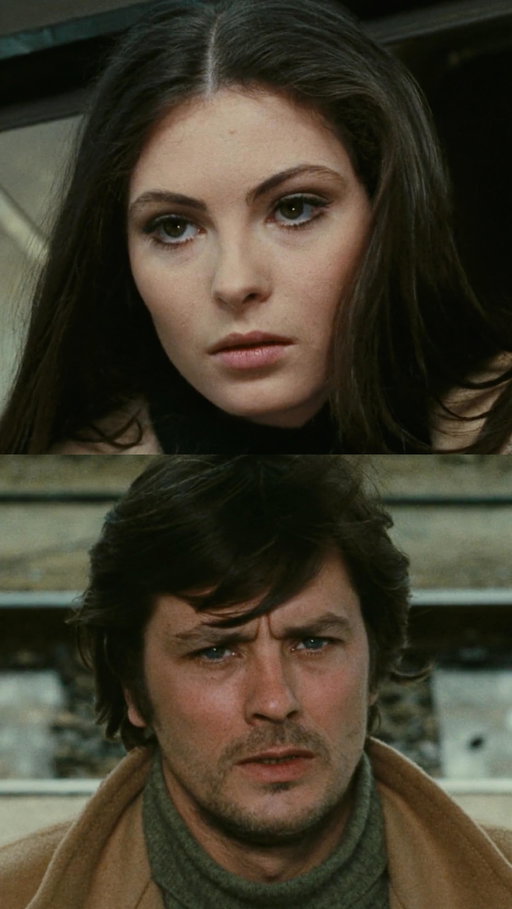 La prima notte di quiete (1972) is a quiet, haunting story about a man who is simply worn out by life.

Directed by Valerio Zurlini, the film shows a very different side of Rimini. There are no sunny beaches or glamorous nights. Instead, we see grey winter skies, empty streets, and buildings that seem to be slowly falling apart. The setting feels cold and tired — just like the main character.

At the center of the story is Daniele Dominici, played by Alain Delon in one of his most vulnerable performances. Daniele is a teacher who arrives in town wearing a worn camel-hair coat, looking as if he hasn’t slept in days. He isn’t starting over. He’s drifting. Beneath his calm surface is disappointment, regret, and a quiet despair he can’t shake.

When he becomes involved with his student Vanina, their relationship doesn’t feel like a typical love story. It feels more like two lonely people recognizing the same sadness in each other. They aren’t chasing happiness — they’re searching for relief.

The film moves with steady melancholy, never offering easy hope. Its title, “The First Night of Quiet,” hints at something unsettling: for some people, peace may not come through love or rest, but only through the stillness of death.

With its somber music and stark winter imagery, the film becomes a poetic reflection on exhaustion, longing, and the strange beauty that can exist inside sadness.