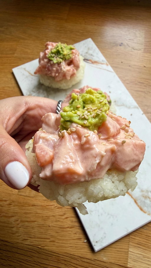 Bolinhos de arroz com salmão cremoso marinado 😋

Ingredientes
2 lombinhos de salmão
Arroz carolino cozido (com textura mais cremosa)
Sumo de meio limão
Sal q.b.
1 colher de sopa bem cheia de queijo creme light (tipo Philadelphia Light)
Meia colher de sopa de polpa de tomate
Meio abacate
Sementes de sésamo q.b.
Azeite em spray 

Preparação
Começa por retirar a pele do salmão e cortar em pedaços pequenos. Tempera com o sumo de limão e sal e deixa marinar enquanto preparas o restante.
Com o arroz já cozido e ainda com uma textura mais cremosa, molda pequenos bolinhos com as mãos, formando bolinhas e achatando ligeiramente. Leva-os a uma frigideira antiaderente com um pouco de azeite em spray e deixa dourar cerca de cinco minutos de cada lado, até ficarem ligeiramente tostados por fora.
À parte, prepara o molho misturando bem o queijo creme light com a polpa de tomate até obteres uma textura homogénea. Adiciona o salmão marinado a este molho e envolve bem, deixando cozinhar até o salmão ficar tenro e cremoso.
Esmaga o meio abacate e divide em três porções. Serve o salmão cremoso por cima de cada bolinho de arroz, acrescenta uma pequena porção de abacate em cada um e finaliza com sementes de sésamo por cima.