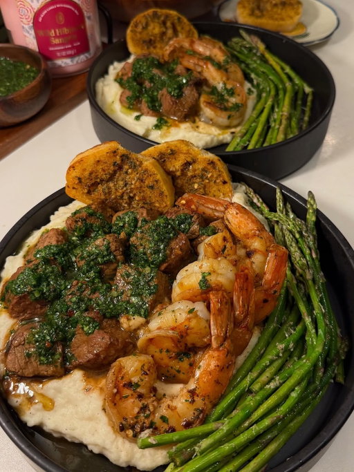 Chimichurri Surf & Turf over Garlic Parm Mash 🥩🍤🌿
(via: @_nutritionwithnat)

🛒 Ingredients
For the Garlic Parmesan Mashed Potatoes
* 2 russet potatoes, peeled and diced
* 1/3 cup heavy cream
* 1 tbsp sour cream
* 2 garlic cloves, minced (or garlic powder)
* 1/4 cup grated Parmesan
* Salt and pepper
For the Chimichurri
* 1 bunch parsley, finely chopped
* 1 bunch cilantro, finely chopped
* 2 tbsp white onion, finely chopped
* 3 garlic cloves, minced
* 1/2 tsp salt
* 1/2 tsp pepper
* 1/2 tsp red pepper flakes
* 1/2 tsp oregano
* ~1/3 cup extra virgin olive oil
* ~2 tbsp red wine vinegar
For the Surf & Turf
* 2 NY strip steaks, cubed
* Worcestershire sauce
* Olive oil
* Salt and pepper
* Steak seasoning of choice
* 1 tbsp garlic butter
* Colossal shrimp, seasoned
For the Sautéed Asparagus
* Asparagus
* Olive oil
* Lemon juice
* Parmesan
* Salt and pepper
* Garlic powder

👩‍🍳 Directions
1. Boil the diced potatoes in salted water until fork tender. Drain and add back to the pot. Mash and stir in heavy cream, sour cream, minced garlic, Parmesan, salt, and pepper until smooth and creamy.
2. Mix together chopped parsley, cilantro, white onion, garlic, salt, pepper, red pepper flakes, oregano, olive oil, and red wine vinegar for the chimichurri. Set aside.
3. Let the steaks rest for 20 minutes. Cube and season with Worcestershire sauce, olive oil, salt, pepper, and steak seasoning. Heat garlic butter in a cast iron on medium-high heat. Add the steak bites and flip after 2 minutes. Toss for 1 additional minute and remove.
4. Immediately add seasoned shrimp to the same pan. Flip after 1 minute and cook until pink and golden.
5. Heat a skillet with olive oil over medium heat. Add asparagus and season with lemon juice, Parmesan, salt, pepper, and garlic powder. Cook until bright green and tender.
6. Plate the Parmesan mashed potatoes and top with steak bites and shrimp. Serve with asparagus and top everything generously with chimichurri.

Subscribe to @EatingHealthyToday for exclusive recipes, viral meal ideas & daily food inspiration you won’t find anywhere else! 🍽️✨

#surfnturf #steakdinner #chimichurri #dinnerideas #datenight