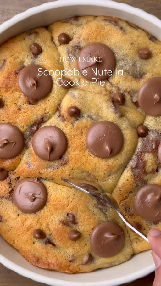 Ooey-Gooey Scoopable Nutella cookie pie 🤤

You can now save this recipe to Osta🤎
To download the Osta app, search “Osta recipes” on the App Store or Google PlayStore🫶🏻

Yields: 8-9 Chunky Cookies
INGREDIENTS:
•115g cold chopped unsalted butter
•80g caster sugar
•80g light brown sugar
•220g chocolate chunks or chips( you can increase or reduce this according to your preference) 
•238g plain flour 
•½ tsp salt
•1 & ½ tsp baking powder
•¼ tsp baking soda
•1 whole egg + egg yolk 
•½ tsp vanilla
•Nutella 
INSTRUCTIONS:
•Cut cling wrap into small squares. Scoop ½ teaspoon Nutella onto individual cling-wrap squares. Fold to seal and freeze until solid. (Repeat for however many Nutella stuffed cookies you plan to make.)
•In a large mixing bowl, add the cold cubed butter and whisk until slightly creamy. Add the white sugar and light brown sugar, then whisk together until well combined and fluffy.
•Add the eggs, vanilla extract, and chocolate chips or chunks. Whisk until fully incorporated.
•Add the flour, baking powder, baking soda, and salt.
Gently mix until just combined, do not overmix.
•Portion the dough into 90g balls. Press a frozen Nutella piece into the centre of each dough ball, seal well, and roll into a smooth ball.
•Place the stuffed cookie dough balls onto a tray and freeze for at least 30 minutes (or overnight for best results).
•Preheat oven to 175-180°C (350°F).
•Take any shape baking dish circle, square, rectangle anything and line it with parchment paper. Arrange frozen cookie dough balls in it leaving some space between them.
•Bake for 20-25 minutes (timing depends on the type of pan) or until the tops are lightly golden while the centres remain soft and gooey.
•Remove from the oven and let cool slightly.
•Serve warm with ice cream and chocolate sauce enjoy!✨
NOTE: Store any extra dough balls in an airtight container or freezer bag and freeze for later. Whenever a cookie craving hits, bake straight from frozen 🫶🏻

#cookie #fyp #chocolate #explorepage #foodstagram