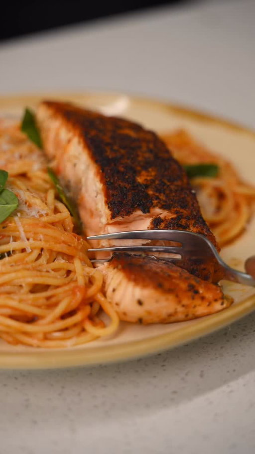 Salmon Tomato Spaghettini

You: Salmon tonight?
Me: Say less 

Pan roasted Salmon, Cherry tomato sauce, Spaghettini 

Ingredients:

* 3 salmon fillets
* Salt
* Black pepper
* Cajun seasoning
* 2 pints cherry tomatoes
* 2 cloves garlic (crushed)
* 1 tsp chili flakes
* 1 tsp salt
* ½ pack spaghettini
* Basil
* Parmigiano-Reggiano
* Olive oil

Method:

1. Season salmon with salt, black pepper, and Cajun seasoning. Heat oil in a pan over medium-high heat. Sear on both sides until deeply golden and cooked to your liking. Remove from the pan and let rest.
2. In the same pan, reduce heat to medium. Add cherry tomatoes and sauté until blistered. Add garlic and chili flakes. Use a masher or a fork to lightly crush the tomatoes into a sauce.
3. Add 1 tsp salt and black pepper. Let simmer until slightly thickened.
4. Cook spaghettini until al dente. Add directly into the sauce and toss.
5. Add basil and Parmigiano-Reggiano. Toss until glossy and emulsified. Taste and adjust seasoning.
6. Plate the spaghettini. Top with salmon. Finish with basil and Parmigiano-Reggiano.

#easyrecipes #salmonpasta #spaghetti
