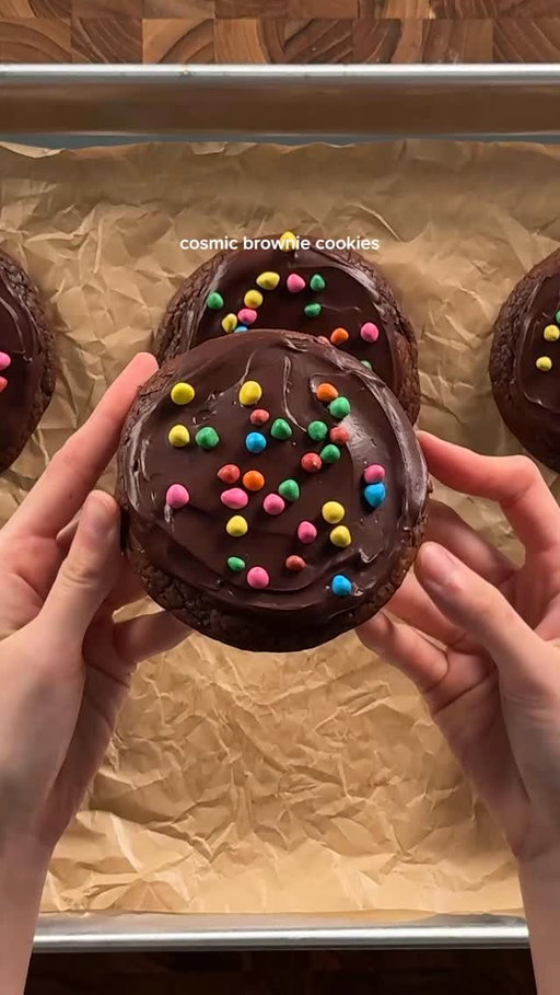 cosmic brownie cookies:
dough:
1 1/3 cups (227g) bittersweet or semisweet chocolate
6 tbsp (85g) unsalted butter
1/3 cup (65g) white sugar
2/3 cup (135g) dark brown sugar
2 eggs
1 tsp vanilla
3/4 cup (95g) flour
1/4 cup (25g) cocoa powder
1 tsp (1g) espresso powder (optional , enhances chocolate flav)
1/2 tsp (2g) salt
*in a microwave safe bowl, microwave butter and chocolate in 15-20 second intervals until it’s melted and smooth. mix in the cocoa powder and then set aside to cool a bit. in another bowl, beat the eggs and sugar well until it becomes more pale and foamy, then slowly add into the choco/butter mixture. mix in the vanilla. in another bowl, whisk together the flour, salt, and espresso powder (optional). gently fold in the dry to the wet. set in the fridge at least 1 hour (makes it easier to work with). scoop and bake at 350 for 13-15 min until the tops look nicely cracked and not “wet”. let cool completely.

ganache:
1 1/3 cups (200g) semisweet or bittersweet chocolate, chopped
1/3 cup (80g) heavy cream
pinch of salt
+rainbow chips
*melt the chocolate and then mix in the heavy cream and pinch of salt. mix until smooth then add on top of the cooled brownie cookies. sprinkle on rainbow chips and then set them in the fridge until the tops set :)