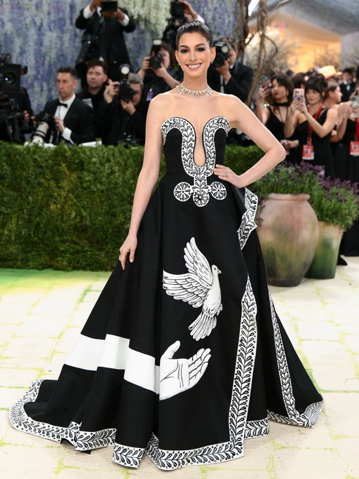 Anne Hathaway arrives at the 2026 Met Gala wearing a custom Michael Kors Collection black silk-and-wool mikado strapless gown with a cascade skirt, featuring one-of-a-kind hand-painted motifs by artist Peter McGough. “We loved collaborating with Anne Hathaway to tell a story that is as old as time: a wish for peace, beauty and harmony.” -Michael Kors 

#AnneHathaway
#MichaelKorsCollection
#MetGala
