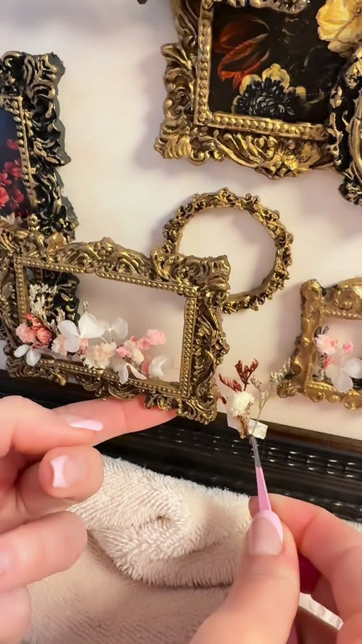 Make miniature vintage frames with hot wax - While I’m slowly collecting real vintage frames one thrift trip at a time for the gallery wall I dream about in my house, I thought it would be fun to create a tiny version first. I used vintage style wax sticks and colored hot glue sticks with silicone frame molds in all different styles and sizes to make these miniature frames feel old and collected. A little gold leaf Rub ’n Buff brought out all the vintage charm, and I added floral art prints in some while letting real dried flowers pop out of others for extra texture, depth and dimension. Now this little piece feels like my own tiny wall of inspiration until I finally collect enough vintage frames for the real thing. #vintagehome #dollhouse #handmade #diy #art