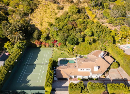 JUST LISTED!

760 N Beverly Glen Blvd
Offered at $8,995,000

A championship tennis court, more than an acre of impeccably landscaped grounds, and exceptional privacy define this remarkable Bel Air estate. Hidden behind mature hedges and gates, the property offers a rare combination of scale, elegance, and resort-style living in Los Angeles’ most sought-after neighborhoods. A sweeping motor court sets a memorable arrival, leading to a stately Georgian residence where timeless architecture and sophisticated interiors blend seamlessly. Flooded with natural light, the home features soaring wood-beamed ceilings, richly detailed millwork, custom stone fireplaces, and expansive windows overlooking the surrounding gardens and grounds. Designed for both grand entertaining and comfortable everyday living, the principal rooms flow effortlessly from one to the next. At the heart of the home is a generously scaled chef’s kitchen with an oversized marble island, premium appliances, and abundant space for gathering and hosting. The residence offers four bedrooms and six baths, including a luxurious primary suite that serves as a private retreat, complete with a fireplace, custom dressing room, spa-inspired bath, oversized walk-in shower, and soaking tub overlooking the grounds. Additional en-suite bedrooms provide comfort and privacy for family and guests alike. Outside, the estate unfolds like a private resort. Expansive lawns, mature trees, vibrant gardens, multiple terraces, outdoor dining areas, a sparkling swimming pool, and a championship tennis court create an extraordinary setting rarely found in Bel Air. Whether hosting large-scale events or enjoying a quiet afternoon at home, the property delivers an unparalleled lifestyle defined by space, privacy, and recreation. A rare opportunity to own a true tennis estate on over an acre in Bel Air.