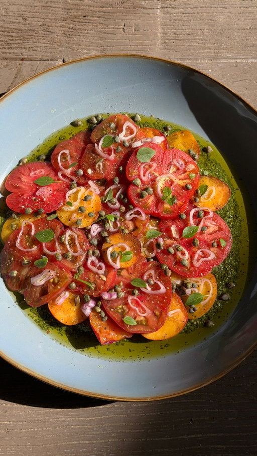 Tomato & Peach Carpaccio on Pesto (recipe ⬇️)
Time: 15 minutes
Serves 4
Ingredients:
* 2–3 heirloom tomatoes, thinly sliced
* 2–3 ripe peaches, thinly sliced
* 1/2 cup pesto (store-bought or homemade)
* 1 shallot, very thinly sliced
* 2 tablespoons capers
* 1 tablespoon olive oil
* Juice of 1/2 lemon
* Salt and freshly cracked black pepper, to taste
Instructions:
Spread the pesto onto the bottom of a large serving plate or shallow bowl.
Arrange the sliced tomatoes and peaches over the pesto, slightly overlapping them for a layered carpaccio effect.
Scatter the thinly sliced shallots and capers over top.
Drizzle with olive oil and fresh lemon juice, then season generously with salt and black pepper.
Let sit for a few minutes before serving so the flavors can meld together. Serve with crusty bread, ideally alongside a glass of chilled wine on a warm evening.

Bon appétit!

📍 Mas de Castillone @domaines.de.chabran 

#easyrecipes #summerrecipes #provence #provencestyle