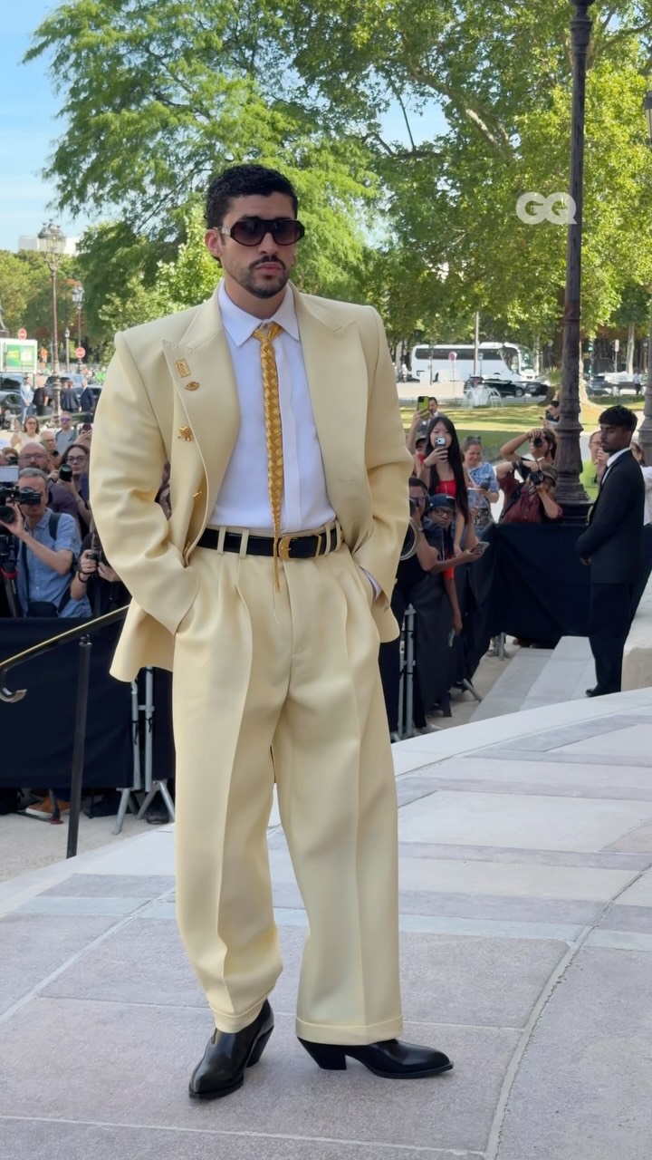 @badbunnypr rolling up to @schiaparelli’s couture show in Paris in pure style, with a braided hair tie, butter yellow suit, and funky heeled boots ⭐️🧈

Video via @enzoply