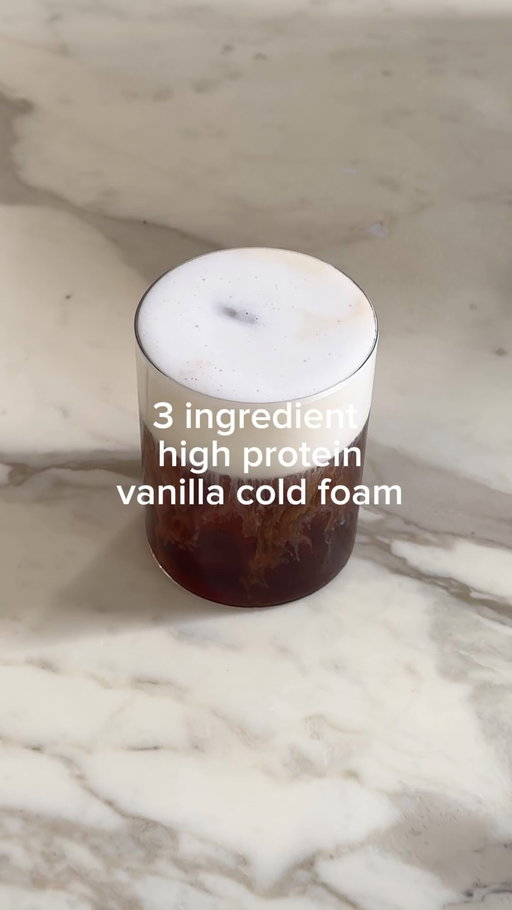 Finally sharing my thick (no cream) vanilla cold foam. This is my go to at home coffee: iced black @nespresso.uk americano with vanilla protein cold foam. 23g of protein per serving. Organic, no rubbish or nasties.
THE RECIPE: 

X2 shots of coffee 
2 tsp or full scoop of clean protein powder, if you don’t want this you can leave it out. Or use collagen powder, it’ll still foam but not be as thick.
100ml milk of choice. Dairy and soy foam up the best 
Vanilla bean paste 1/4 tsp (optional)
Generous splash of maple syrup 
Ice

The order is important:
Ice in a cup, brew your coffee over the ice 
Milk into separate cup, add your additions and whisk with a hand whisk
Once really foamy pour over espresso and enjoy 🧘🏼‍♀️