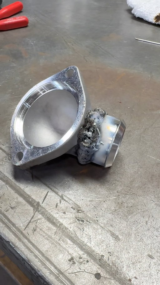 What would you have done differently? 

After trying to burn out some of the impurities then fill and grind, @brandongerringer decided the dumpster was the logical next step. Sometimes you can weld cast aluminum but whatever this stuff was, it was not happening. 
 
(Instead, Paul found an adjustable billet thermostat housing online that should do quite nicely)