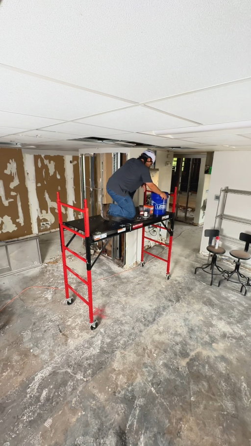 Knocking out tile ceilings with the Upgraded Baker Scaffold. It fits through doorways easily, rolls on double locking casters, and features an integrated hatch for safe climbing. 🛠️