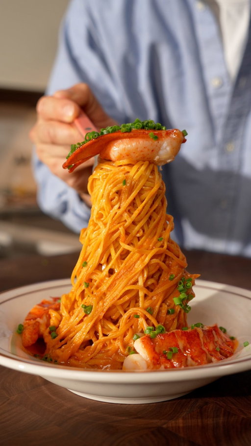 Feeding me pasta and lobster🦞🍝

Ingredients

Fresh Pasta
- 1 cup 00 flour
- 7 egg yolks or 3 whole eggs
- Olive oil
- Chives

Lobster Cream
- 2 lobsters
- 2 shallots
- Garlic
- 1 large carrot
- 1 tbsp tomato paste
- 1 cup Cognac (optional)
- 500 ml heavy cream
- Tarragon
- Thyme
- 1 bay leaf
- Cherry tomatoes
- Butter
- Chilli

Instructions

Lobster Cream
1. Boil the lobster tails for 4 minutes and the claws for 5 minutes. Transfer immediately to ice water to stop the cooking.
2. Crack the shells and gently remove the meat. Set aside.
3. Heat a drizzle of olive oil in a pan. Add the carrots, shallots, garlic, and lobster shells. Cook until softened.
4. Deglaze with Cognac and let the alcohol cook off.
5. Add the heavy cream, tarragon, thyme, and bay leaf. Simmer gently for 1 hour.
6. Strain through a fine sieve and set the lobster cream aside.

Fresh Pasta
1. Place the flour on a work surface and make a well in the centre. Add the egg yolks.
2. Gradually incorporate the flour and knead until you have a smooth dough.
3. Wrap tightly and rest for 1 hour.
4. Cut the dough in half and roll each piece into a thin sheet.
5. Cut into tagliolini using a pasta machine or by hand.

Assembly
1. Heat a drizzle of olive oil in a pan. Add the chopped shallots, garlic, chilli, and tarragon.
2. Add the tomato paste and cook for 1–2 minutes.
3. Add the cherry tomatoes and cook until softened.
4. Pour in the lobster cream and gently simmer.
5. Cook the pasta in salted boiling water for 2–3 minutes.
6. Add the pasta to the sauce with 2 tbsp of pasta water. Toss until well coated.
