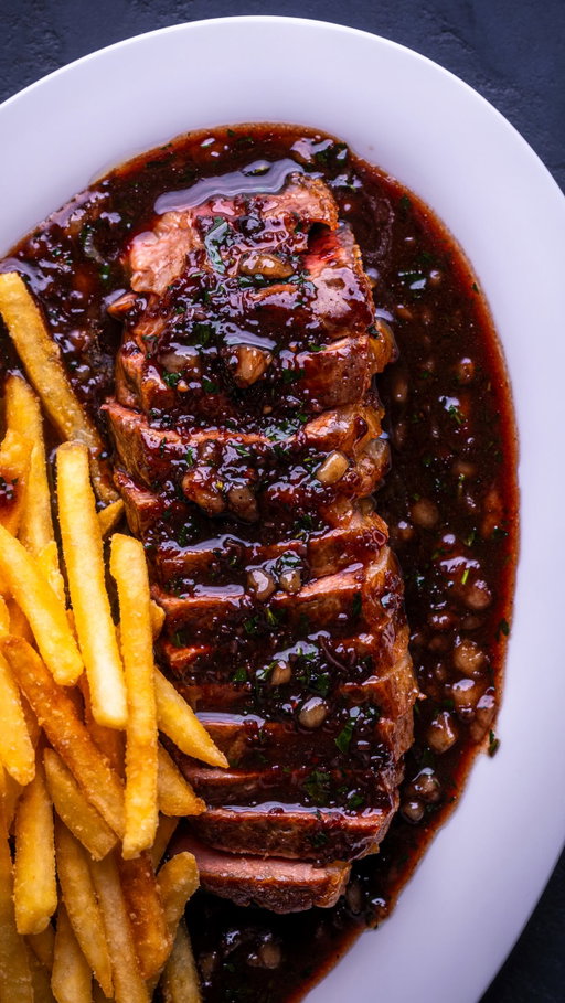 Steak with Bordelaise Sauce

My wife and I had this at Brasserie Zédel earlier this year and both went quiet in the way you do when something is properly good. She made me promise I’d make one as good at home. I think I’ve got there.

Red wine, shallots, stock, bone marrow. That’s it. The marrow goes in off the heat and gives the sauce a gloss no amount of cream would get you.

Serves 2

INGREDIENTS 400g sirloin steak, room temp for 2 hrs Salt and pepper Tallow or your cooking fat of choice 2 banana shallots, finely sliced 2 tbsp unsalted butter 2 canoes bone marrow, scraped raw 70ml red wine vinegar 250ml Bordeaux or other dry red 250ml good beef or veal stock 10g flat-leaf parsley, chopped

METHOD
1. Oven to 70°C. Salt the steaks just before they hit the pan.
2. Sear over medium heat, 2 to 3 mins, turning every 20 to 30 seconds. Rest in the oven 10 mins.
3. Back in the pan for 30 secs to build the crust, then back in the oven, dropped to 50°C, while you make the sauce.
4. In the same pan, low heat: shallots, a little marrow, some butter, salt and pepper. 5 to 7 mins until translucent.
5. Vinegar in, cook until jammy. Wine in, heat up high, reduce 8 to 10 mins until a spoon leaves a clear trace on the pan.
6. Stock in, reduce 5 to 7 mins until it coats a spoon. Heat to low.
7. Remaining marrow and butter in. Swirl constantly for a minute until emulsified. Off the heat, parsley in.
8. Taste, salt, serve.