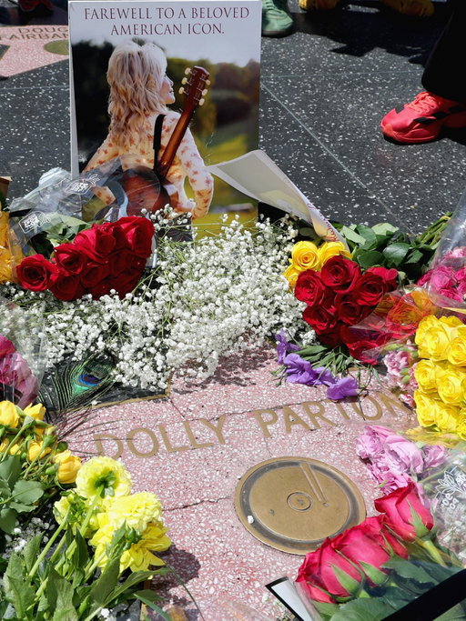 Dolly Parton forever.💗 Fans cover #DollyParton’s star on the Hollywood Walk of Fame with flowers in memory of the country music legend.