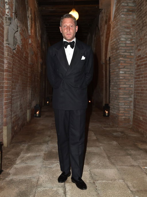 Lapo Elkann wearing an impeccable bespoke double-breasted tuxedo, cut in black summer kid mohair with matt gros-grain silk lapels.

But this time, let’s not focus on the execution of the tuxedo itself. Let’s focus instead on the nonchalance with which Lapo wears it.

The first detail you may notice is that he doesn’t fasten the inner button of the jacket. This creates a subtle fold around the outer button, giving the jacket a more relaxed, less formal attitude.

And then there is the posture.

Anyone else would probably have posed in a way designed to make the outfit look as perfect as possible. Not him.
Hands crossed behind his back, almost saying: “I don’t care.”

And that, right there, is personality!

My dear friend has plenty of it.

At the same time, the bow tie, strictly hand-tied, tells you that he knows exactly what he is wearing. True elegance is also about understanding the rules well enough to bend them naturally.

Then there are the trousers: pleated, with a leg that is wide but not too wide, long but not too long. Just enough to create that impeccable 1960s silhouette.

Loafers and black silk socks to finish.

And then there is a detail that very few will notice.

We know. Because we made it.

The bartack of the chest buttonhole, just 0.5 cm wide, is hand-stitched in the three colours of the Italian flag. Not only is it an extremely difficult detail to execute, but it is also a small gesture of belonging, a detail we dedicate exclusively to Lapo.

Many have asked us to reproduce it.

Our answer is always the same: we simply cannot.

You can take inspiration from a person, from their attitude, from the way they wear clothes. But copying their details would never be the same thing.

Because style is not about reproducing someone else’s signature.

It is about having your own.

To each his own.
And that is exactly why we are here, my friends. 

@rubinacci_official The Art of Tailoring 🪡 

#LapoElkann #LucaRubinacci #Rubinacci #BespokeTailoring #BespokeTuxedo