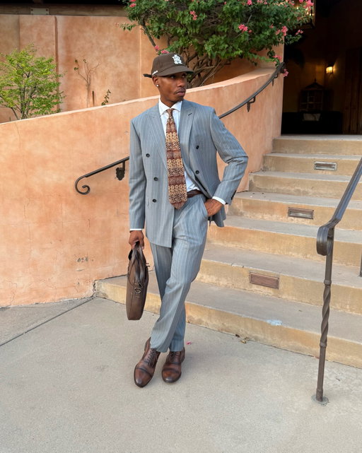 Styling my custom gray pinstripe suit, courtesy of @thegrottomenswearphoenix . Crafted with a sharp double-breasted silhouette, classic pinstripes, and a fit tailored specifically to me, it strikes the perfect balance between timeless sophistication and modern personal style. Designed with versatility in mind, it can be worn traditionally or styled more casually with unexpected accessories.

The craftsmanship, attention to detail, and experience of creating this one from the ground up made this look really stand out. From selecting the fabric and custom purple lining to seeing the final fit come together, every detail feels intentional. Safe to say, this is a suit that speaks for itself. 👔