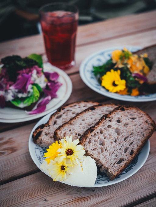 Werbung | Frisches Sauerteigbrot mit aufgeschlagener Butter, Smørrebrød und dreierlei vom Kürbis mit Blüten, die eine halbe Stunde vorher noch im Beet standen... 😍

Kommt ihr mit @diejungskochenundbacken und mir nach Fjordlandet? 🇩🇰🙋🏼‍♀️ Gestern hatten wir einen wunderschönen ersten Tag und ich möchte euch direkt ein Highlight zeigen:

Sct. Hans Have in Roskilde ist ein alter Klinikgarten am Fjord, nur eine halbe Stunde mit der Bahn von Kopenhagen entfernt und perfekt für eine Auszeit im Grünen! 👌🏻

Gewächshäuser mit Feigen- und Mandelbäumen, langen Tischen und Schaffellen über den Stühlen laden ein, es sich hier gemütlich zu machen. Seit über 200 Jahren werden Obst, Gemüse und Blumen angebaut. Heute arbeiten Patientinnen und Patienten aus der Psychiatrie, Freiwillige und Angestellte zusammen im Garten und im Café. In die Küche kommt, was die Region hergibt.
Maria-Louise ist hier schon groß geworden und hat uns mit ihrem Nachbarn Heiner herumgeführt.

Geöffnet mittwochs bis sonntags, 11 bis 17 Uhr und definitiv einen Besuch wert. Probiert unbedingt das Brot mit Butter! 😅

Habt ihr genauso wie ich Lust auf noch mehr dänische Rezepte im Blog, die ich hier teile? 🇩🇰
Und wie wäre es mit einem kleinen Gewinnspiel mit ein paar Mitbringseln? Seid ihr dabei? 🙋🏼‍♀️

@sct.hanshave @visitfjordlandet @govisitdenmark

#roskilde #fjordlandet #dänemark #visitdenmark #gartencafé