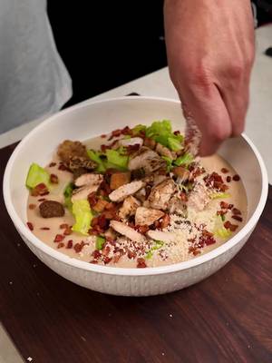 Chicken Caesar Salad Soup. Smash 👍🏻 or Pass 👎🏻 RECIPE 1 pound of chopped bacon 1 diced onion 5 cloves of garlic 1 large russet potato  4 cups chicken stock 2 cups heavy cream 1/4 cup chopped anchovies 1/2 cup grated parmesan cheese Juice of a lemon 1 cup chopped romaine lettuce 1 cup croutons 4 large chicken tenders 1 tbsp garlic powder Fry the bacon in a large soup pot, then extract the bacon and leave the grease. Add the onions garlic and potatoes and saute for about 5 minutes just until the onions are softened  Add the chicken stock and season with a generous amount of salt and pepper Simmer for about 10 minutes Chop up the anchovies, and grated the parmesan cheese Add it to the soup and using a hand blender or regular blender, puree the soup until its a smooth consistency Stir in the heavy cream and lemon juice Season the chicken with salt, pepper, and garlic powder and grill on both sides for about 3 minutes aside. Then chop it up Add the soup base to a bowl, place the lettuce on top, followed by the croutons, chicken, chopped bacon and some more parmesan cheese. Hit it with some lemon juice and enjoy 