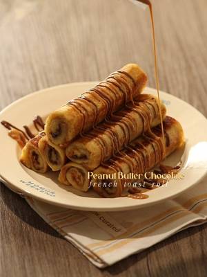 🥜🍫 Peanut Butter Chocolate French Toast Rolls 📝 Recipe 6 Slices • Bread 3 tbsp • Peanut Butter 3 tbsp • Chocolate Spread 1 Egg 30ml • Milk 1 tbsp • Butter Instructions: • Bread - flatten the bread with rolling pin - spread peanut butter on half of the bread - spread chocolate spread on the other half of the bread - roll the flatten bread - cut the edges of the rolled bread • Soaking; Bread - crack open 1 egg - pour milk and whisk everything - soak the bread in the mixture • Cooking; Bread - put butter on a pan in medium heat - fry the bread and flip every sides until golden brown • Finishing; PB Chocolate French Toast Roll - serve the french toast rolls with drizzle of peanut butter — #homecafe #peanutbutter #asmr #homecooking #frenchtoast 