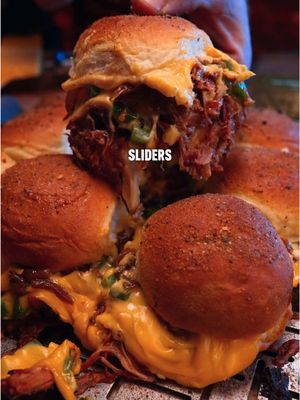 Cheesy Pulled Pork Sliders 🔥 Recipe: -Start with the bottom half of a pack of slider buns. -Lay down a layer of shredded Monterey Jack cheese. -A layer of sauced up pulled pork. -American cheese -Chopped Jalapeño Peppers -Caramelized Onions -More American Cheese -Return the top buns, paint with melted butter, and dust with parmesan garlic seasoning. -Place on the grill at 325F indirect for at least 20 minutes to melt the cheese. -Pull apart and enjoy!